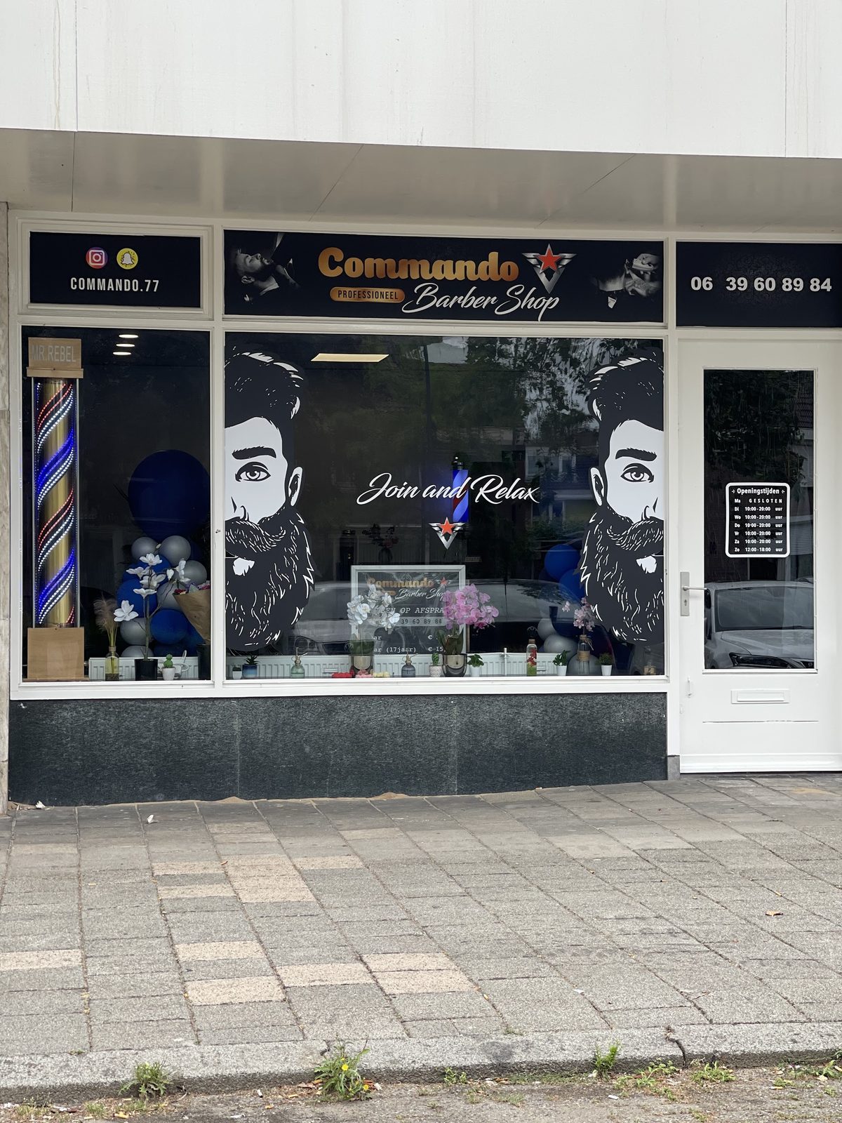 De gevel van Commando Barbershop aan de Churchilllaan 93, met het uithangbord en de barbierspaal naast de deur